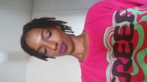 Black Girl wearing makeup with medium sized dreadlocks. She has on a shirt that reads "Creep".